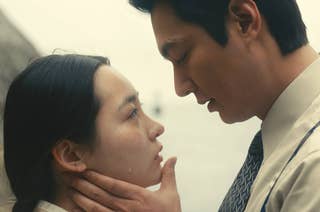 Minha Kim and Lee Min-ho share an emotional moment, closely facing each other as Lee gently holds Kim's chin, a tear on her cheek